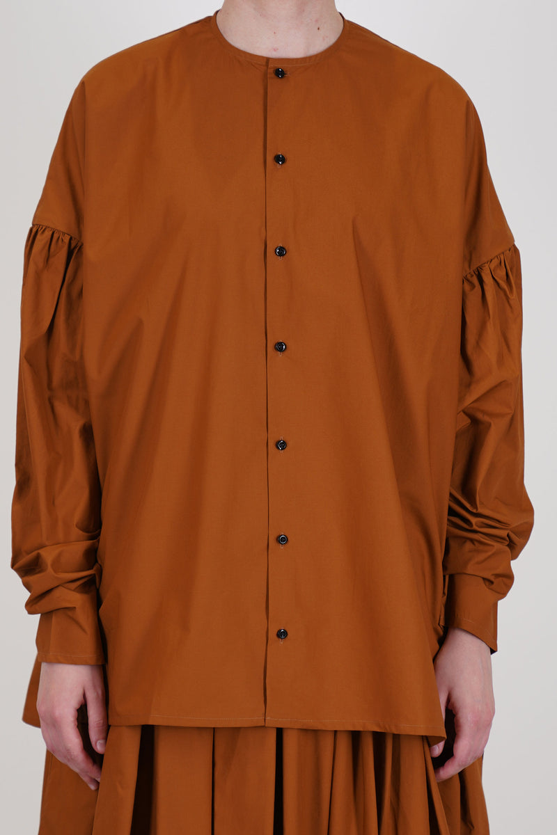front view of école de curiosités shirt basil caramel brown features dropped shoulders and voluminous long sleeves