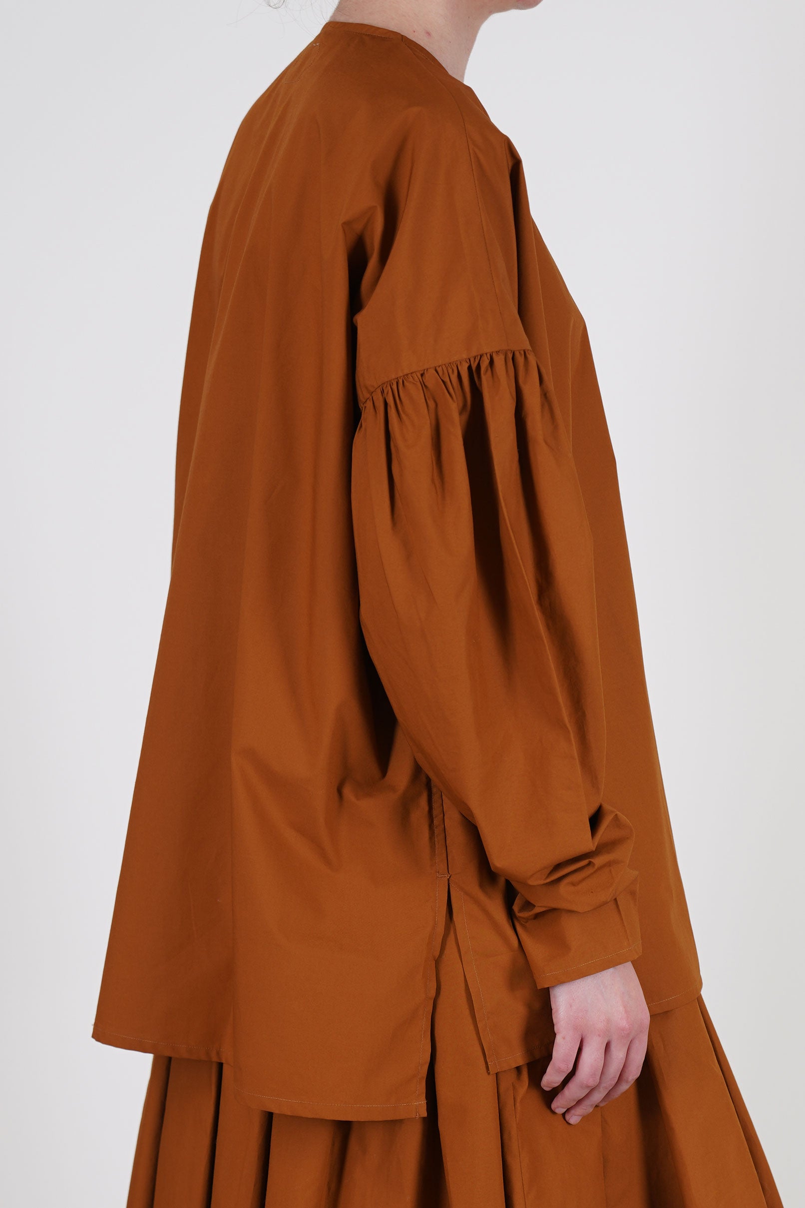detail view of école de curiosités shirt basil caramel brown voluminous long sleeves, enhanced by subtle gathered details at the upper arms and tapered narrow fit at the cuffs. 