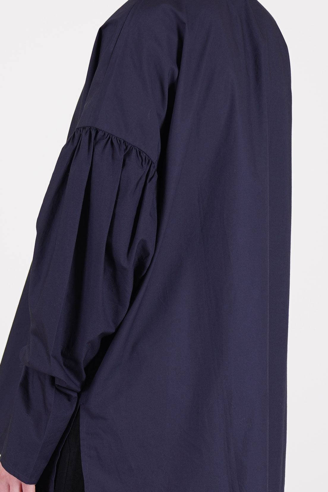 side view of école de curiosités shirt basil dark navy long sleeves, enhanced by subtle gathered details at the upper arms and tapered narrow fit at the cuffs. 