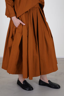 detail view of école de curiosités skirt solange caramel brown midi skirt designed with box pleats and gentle gathers to create a voluminous silhouette.