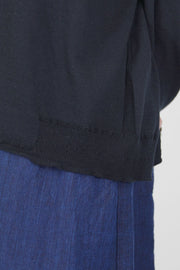 close up detail view of pas de calais cardigan cotton linen black knitted design at the side hemline